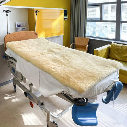 Onderdeken van schapenvacht voor op het bed. Medische matras van schapenvacht